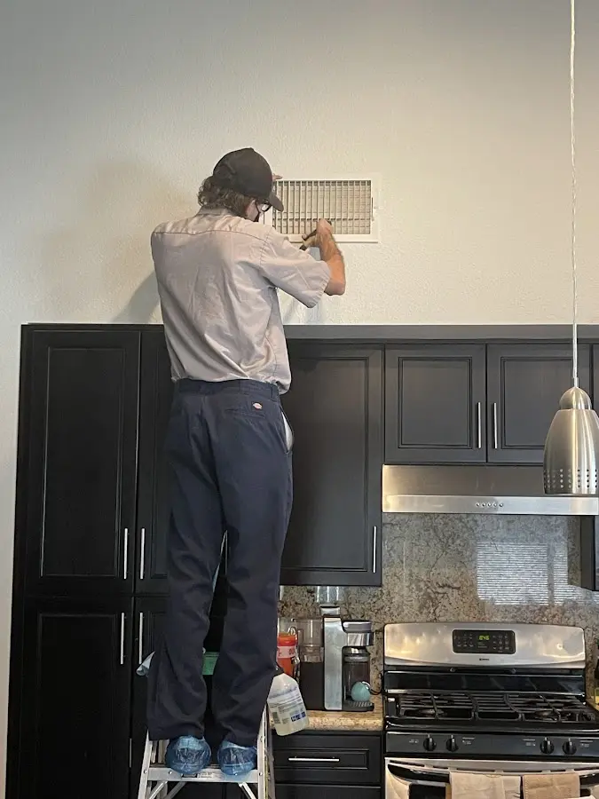 Technician inspecting an air vent during HVAC service in Smyrna